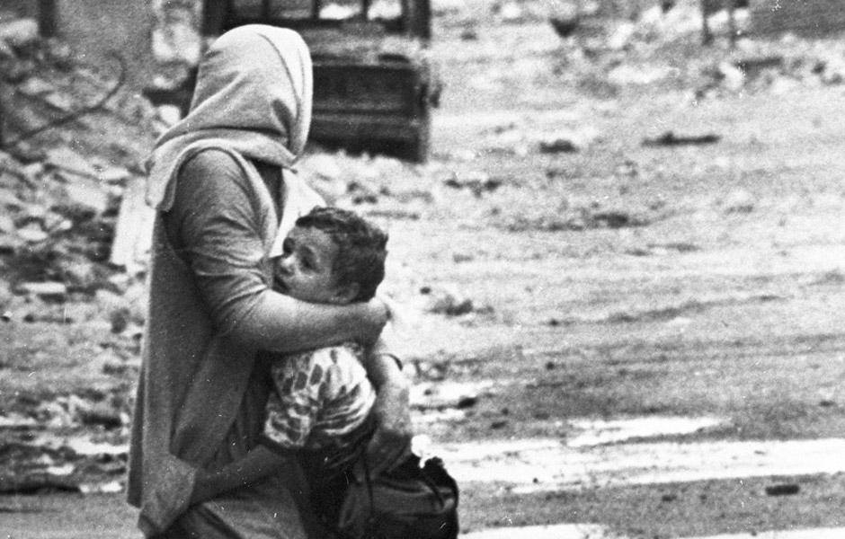 A Palestinian refugee and her child caught in sniper fire during the War of Camps. Author: unknown